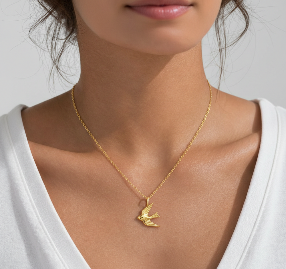 the beehive 18k gold plated brass pendant necklace featuring a 3D soaring bird design worn on a woman